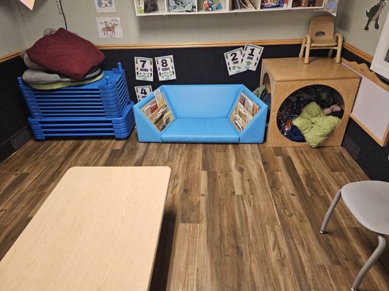 Classroom with a blue couch, wooden cubby, and small table