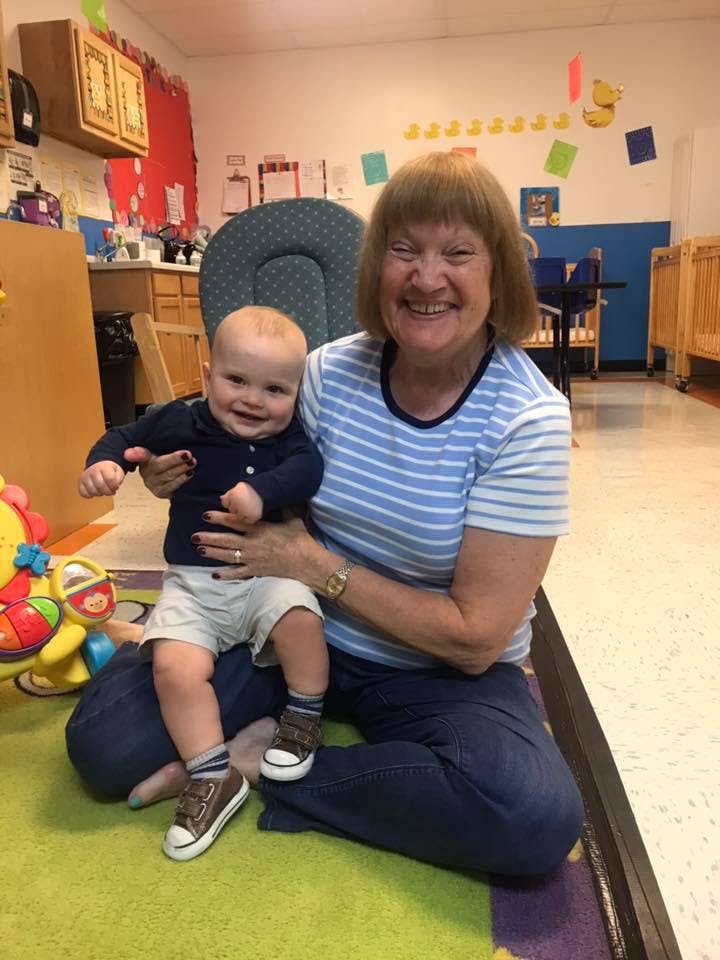 Person holding a child in a classroom