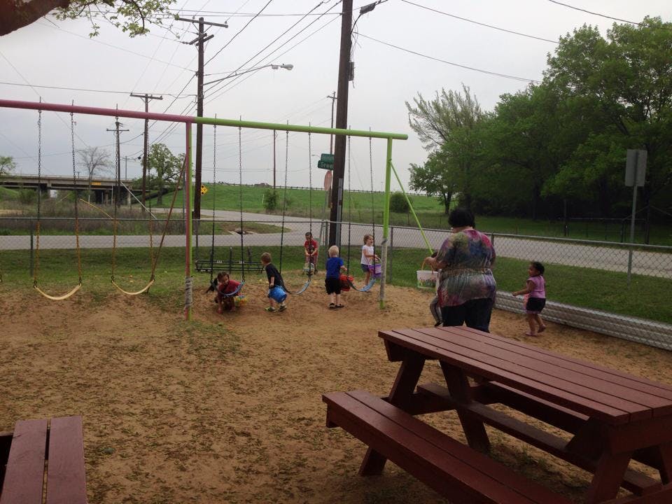 People and children on a playground with swings