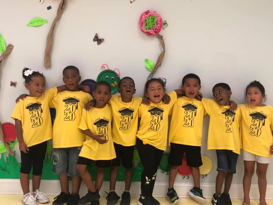 Group of children in yellow shirts with graduation cap design