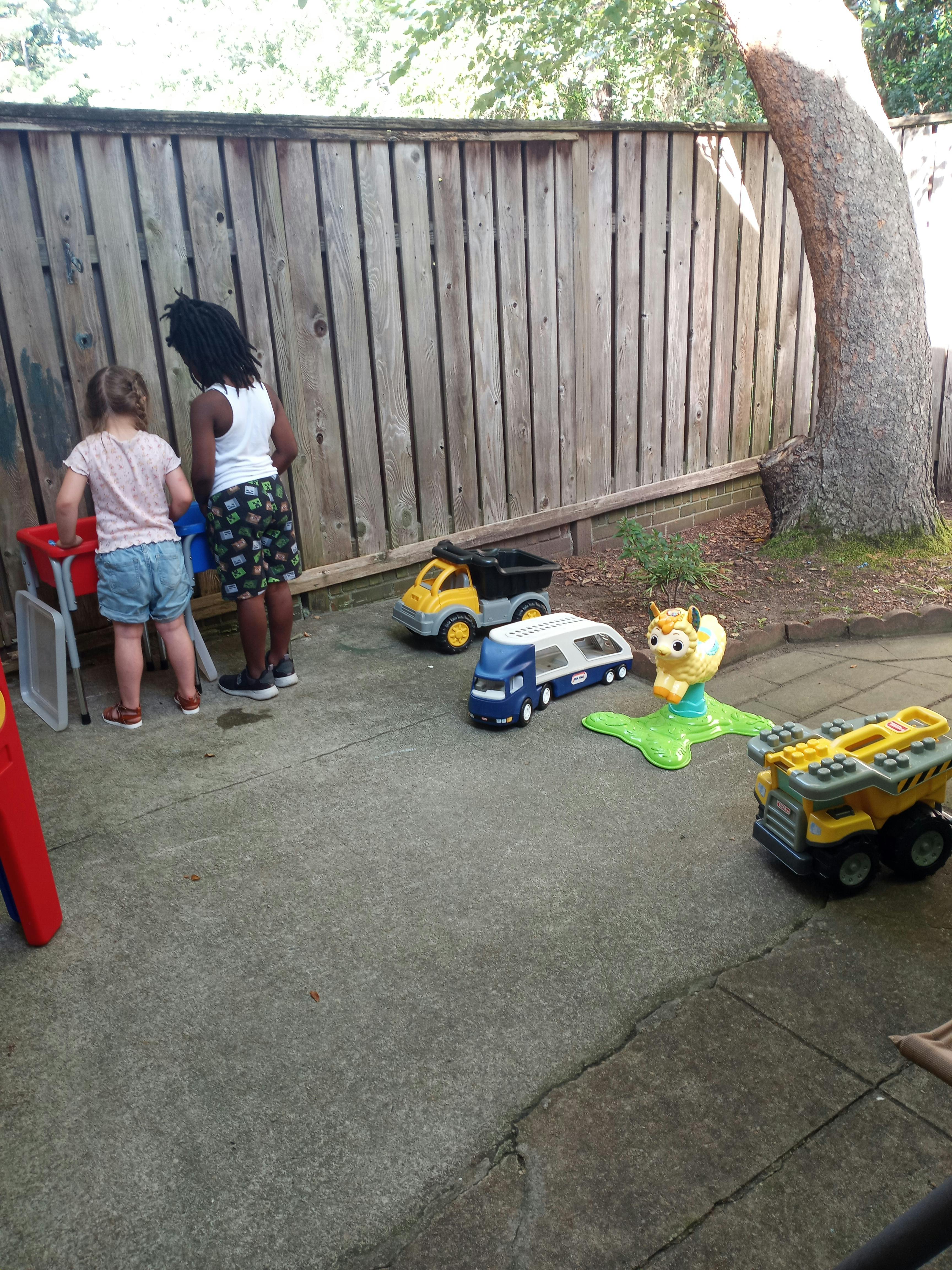 Two children playing with toys on a patio