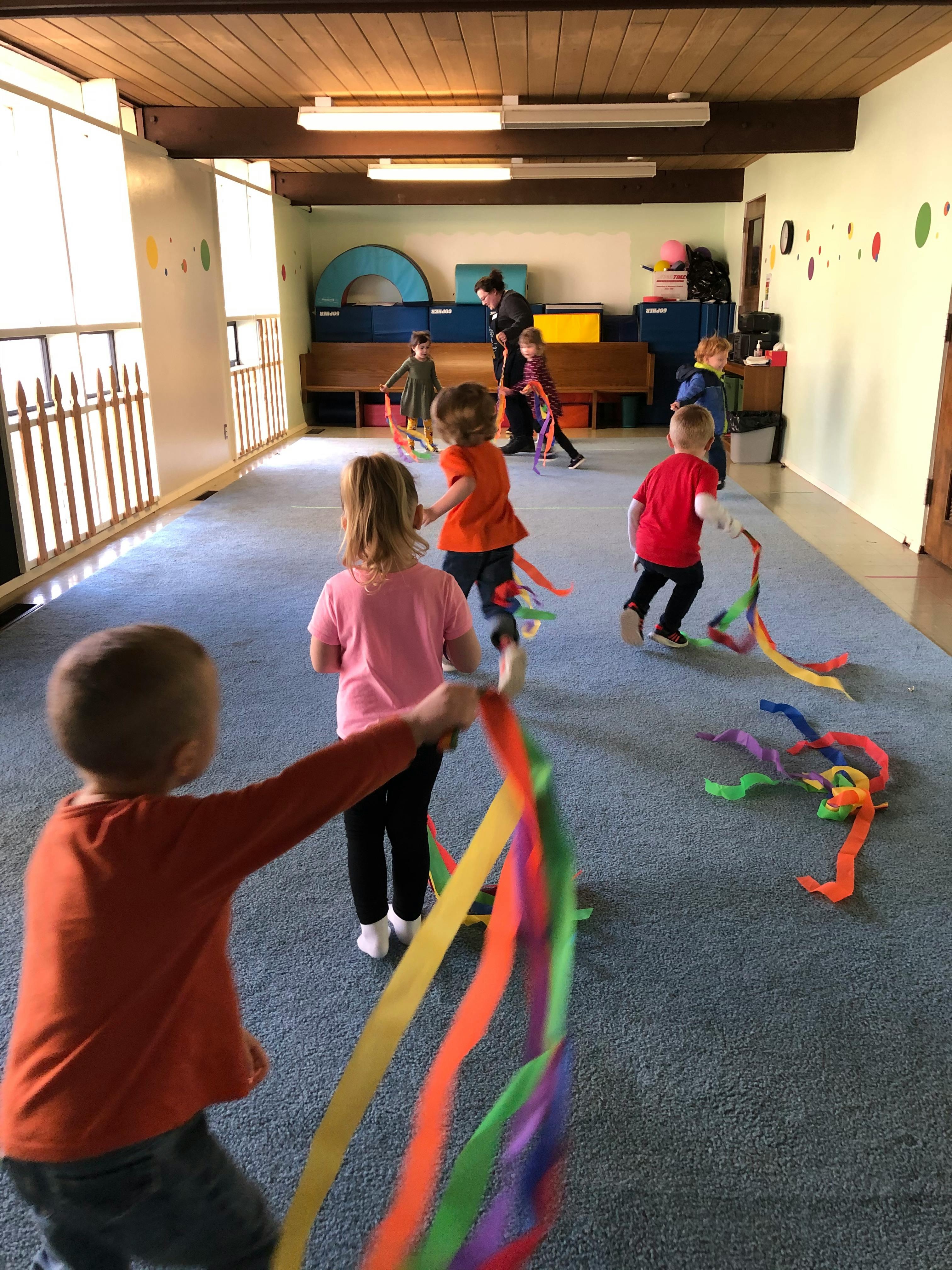 Children playing with colorful ribbons in a room