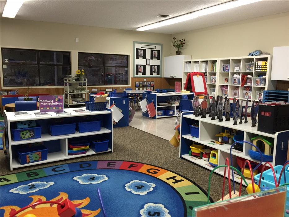 An empty early childhood classroom with a colorful alphabet rug