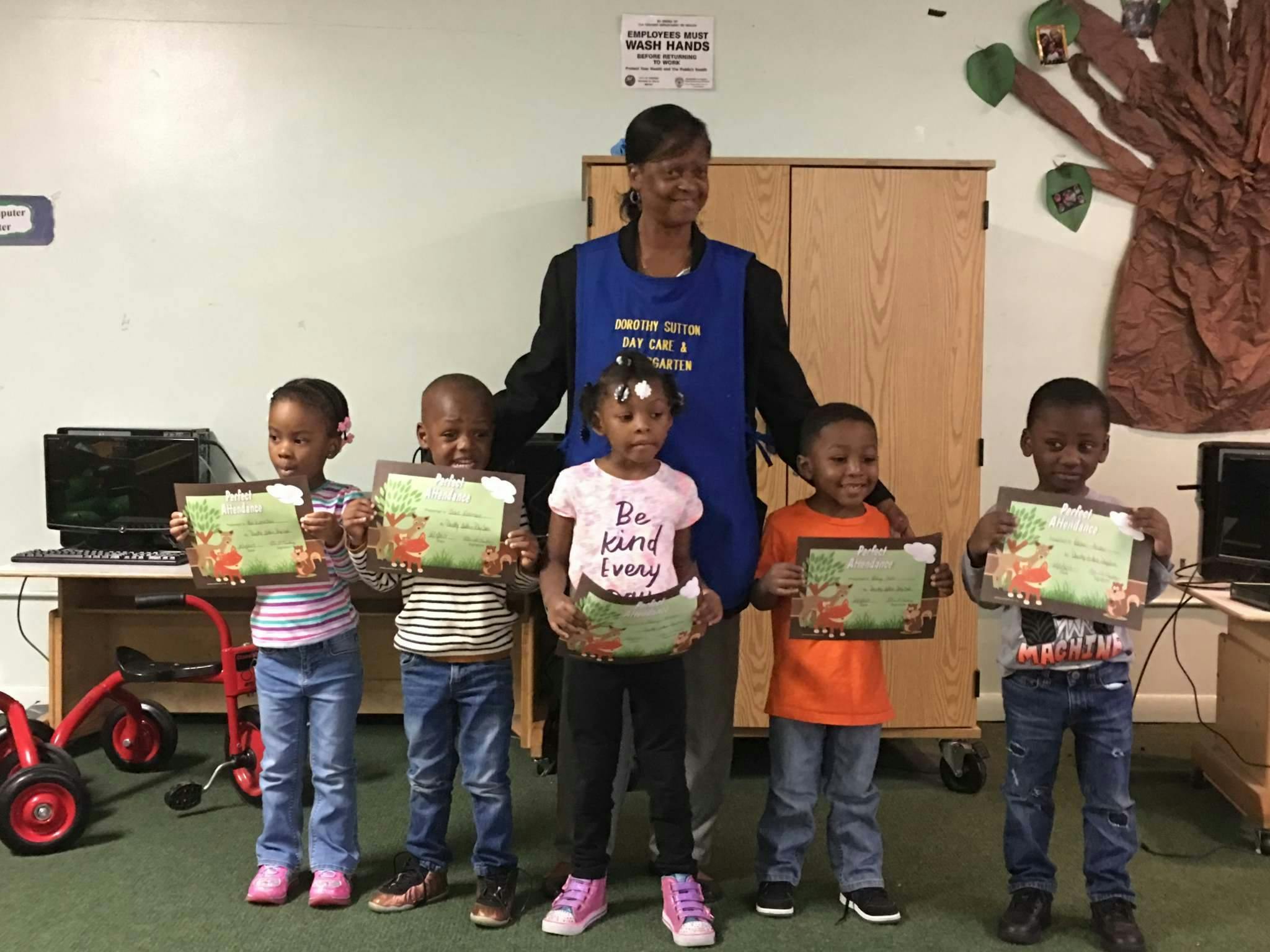 Adult and five children holding certificates