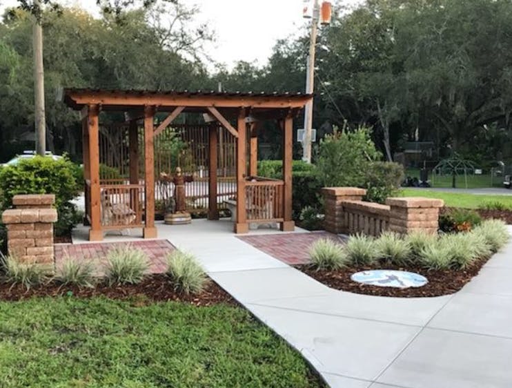 Wooden gazebo with a metal roof and brick pillars