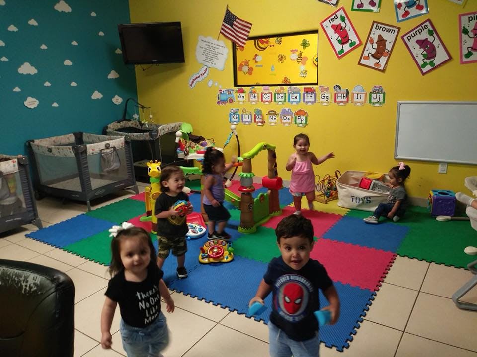 Children playing in a colorful room with play mats and toys