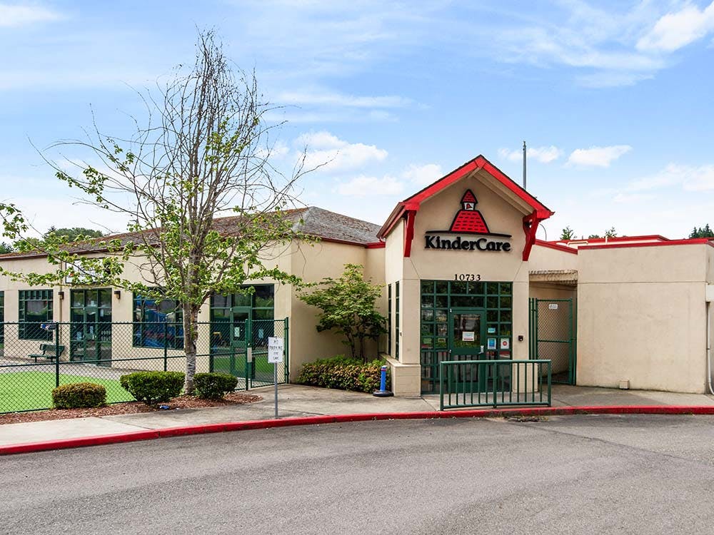 KinderCare building exterior with a play area behind a fence