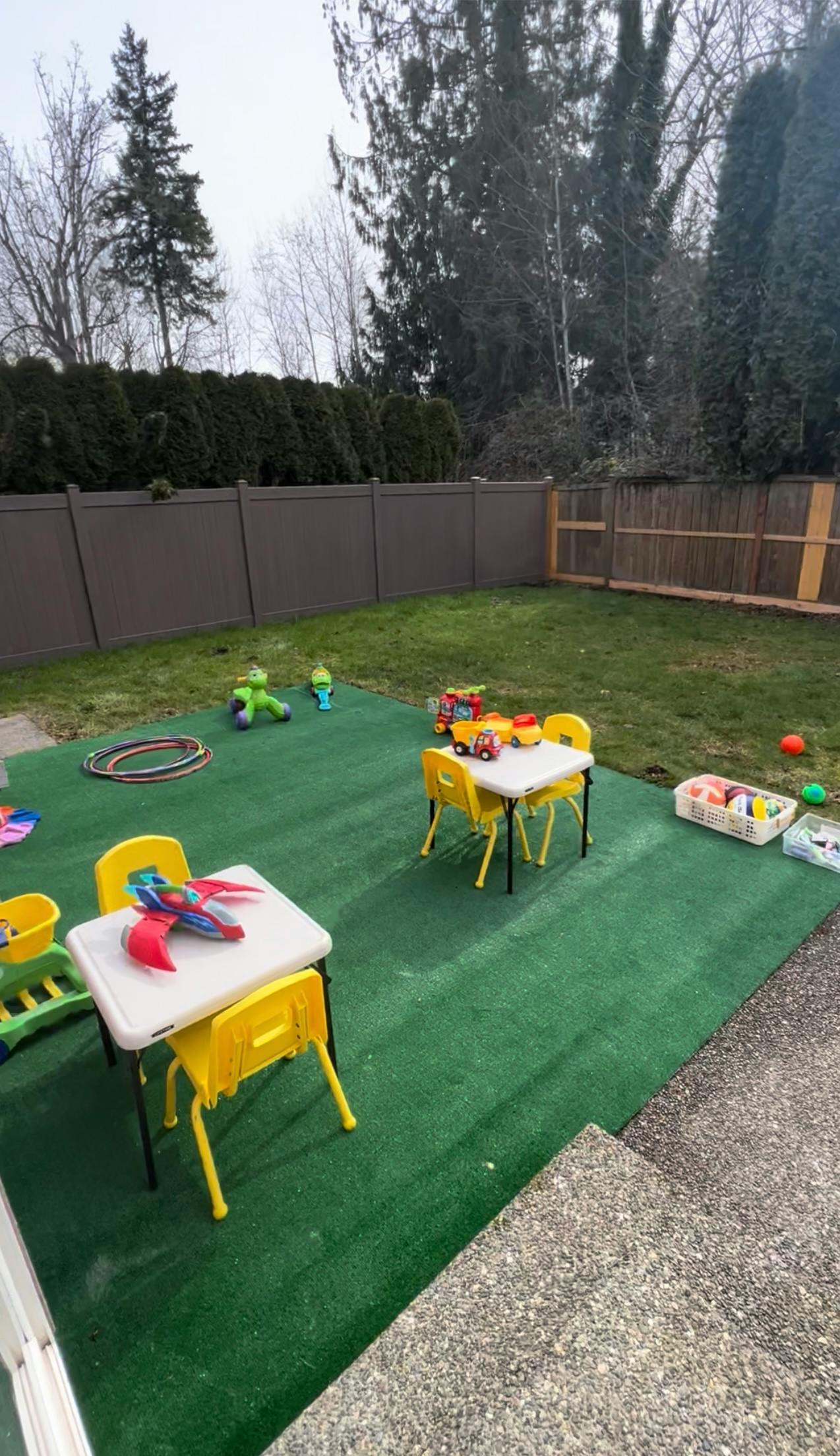 Outdoor play area with small tables and chairs on green turf