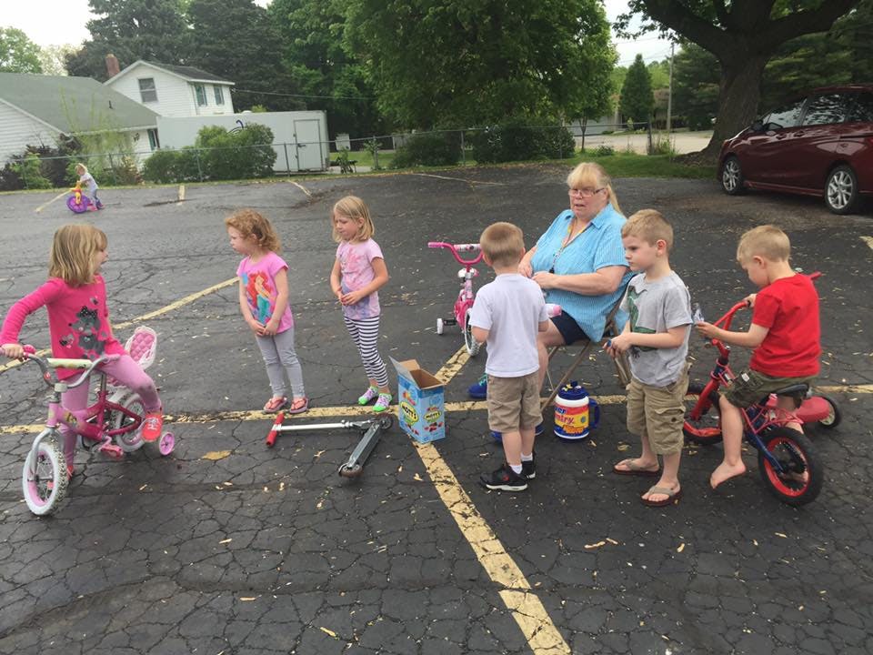 Adult and children with bicycles in a parking lot
