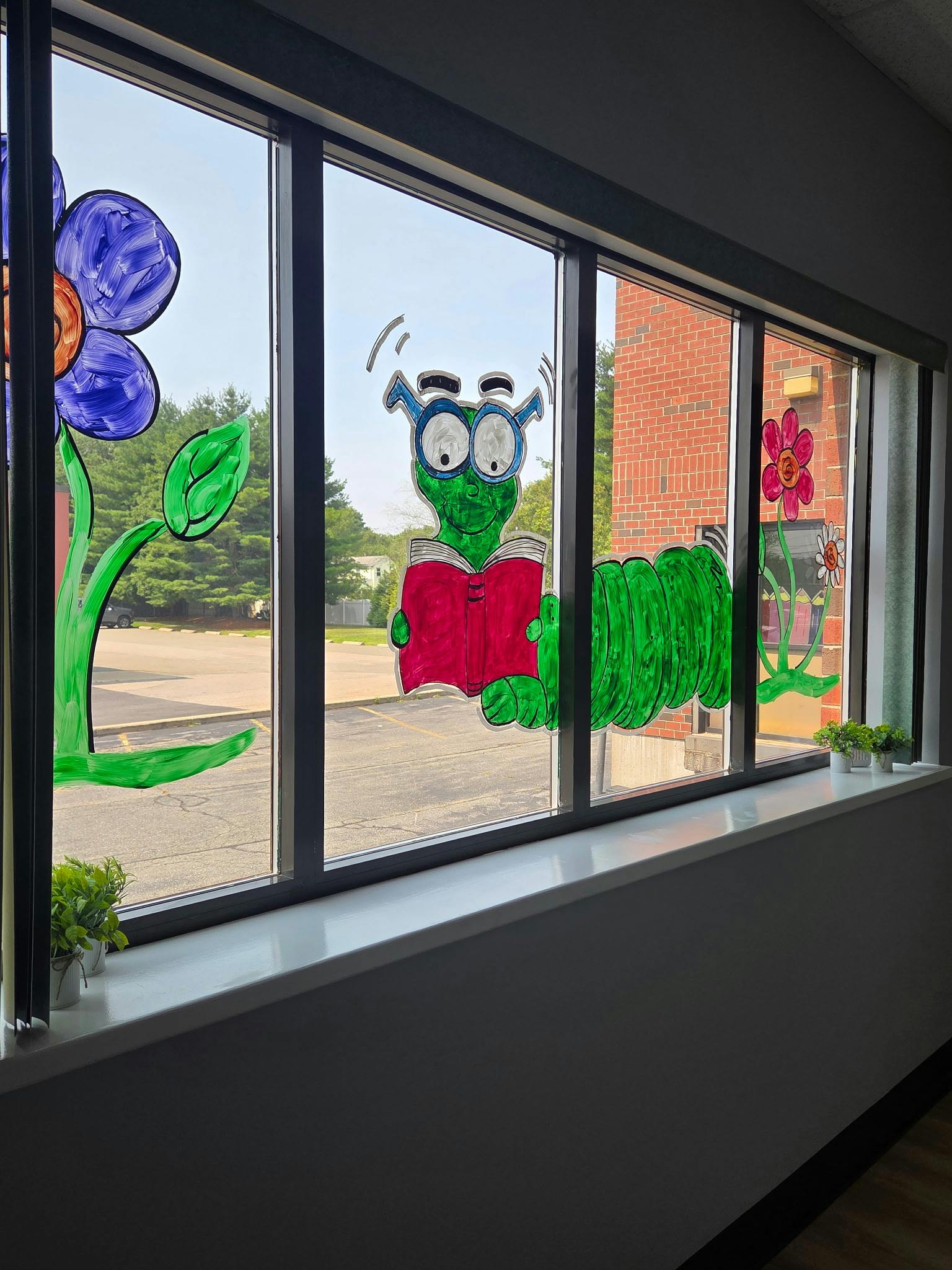 Caterpillar wearing glasses and reading a book painted on a window