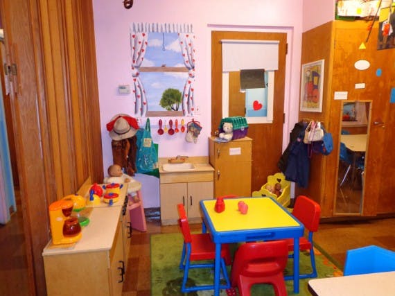 Playroom with small table and chairs, toy kitchen, and other toys