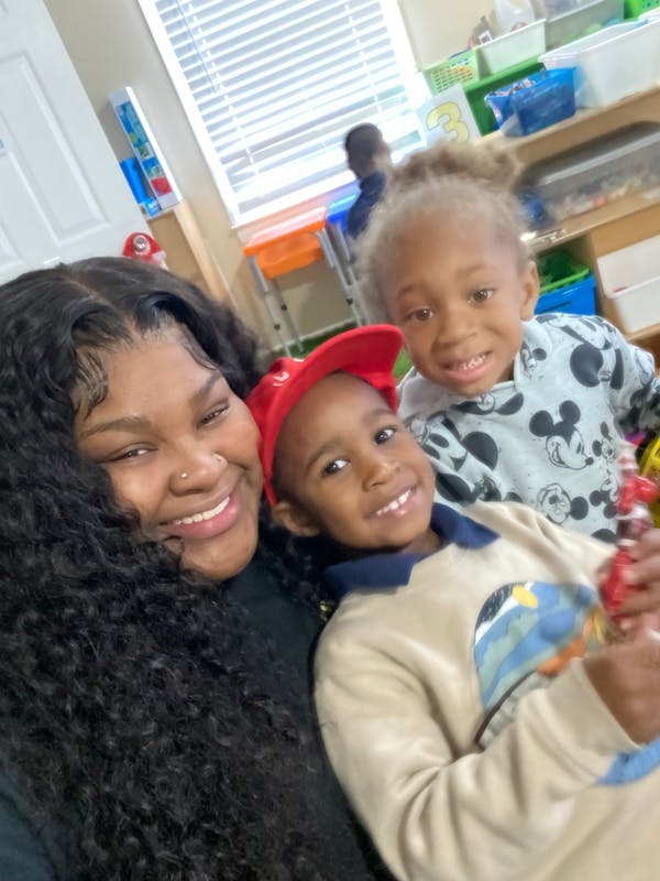 Person with two children in a classroom