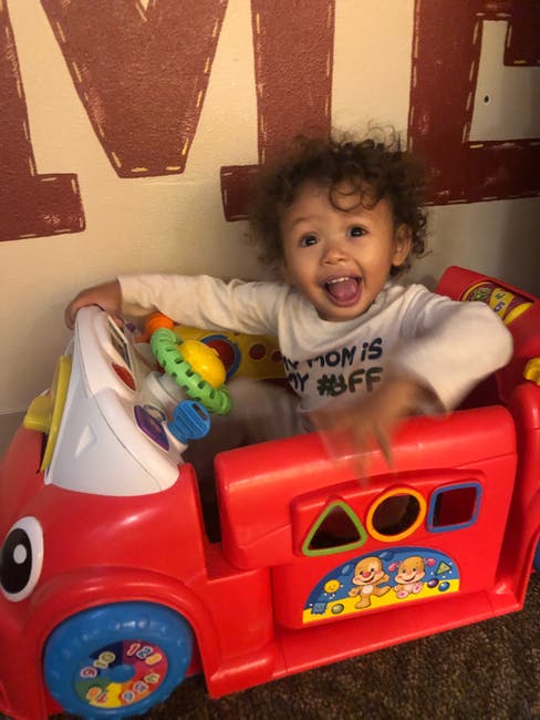Child in a red toy car