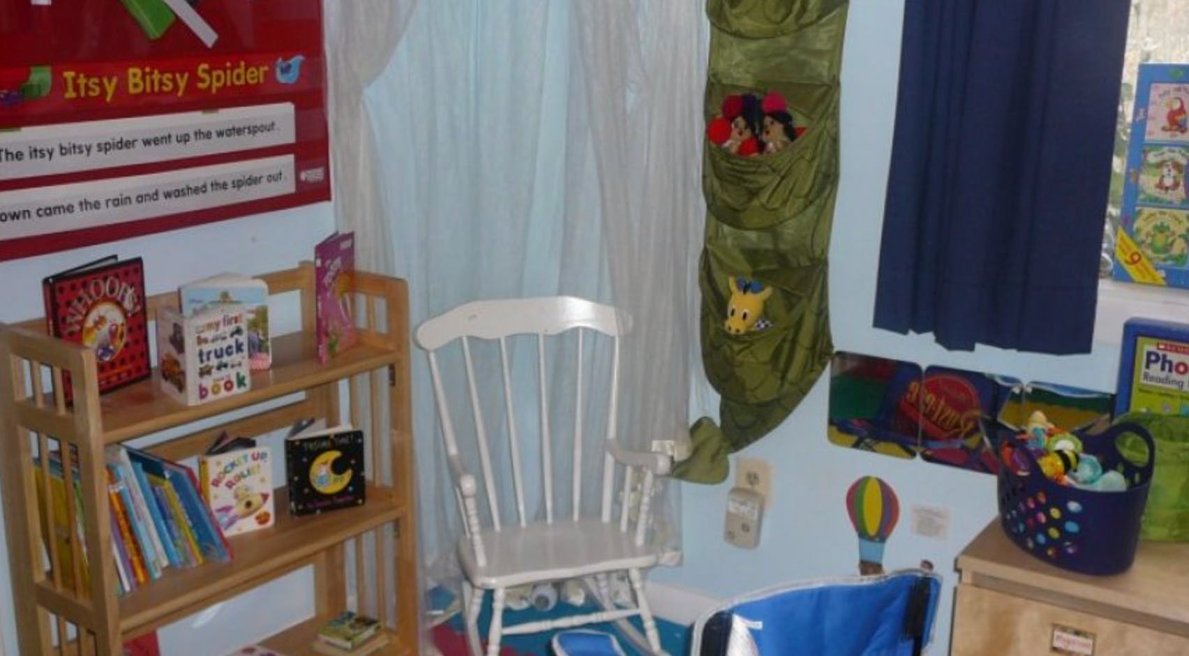 Child's room with a bookshelf, white chair, and wall decorations
