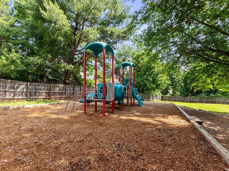 Playground structure with slides and climbing bars over wood chips
