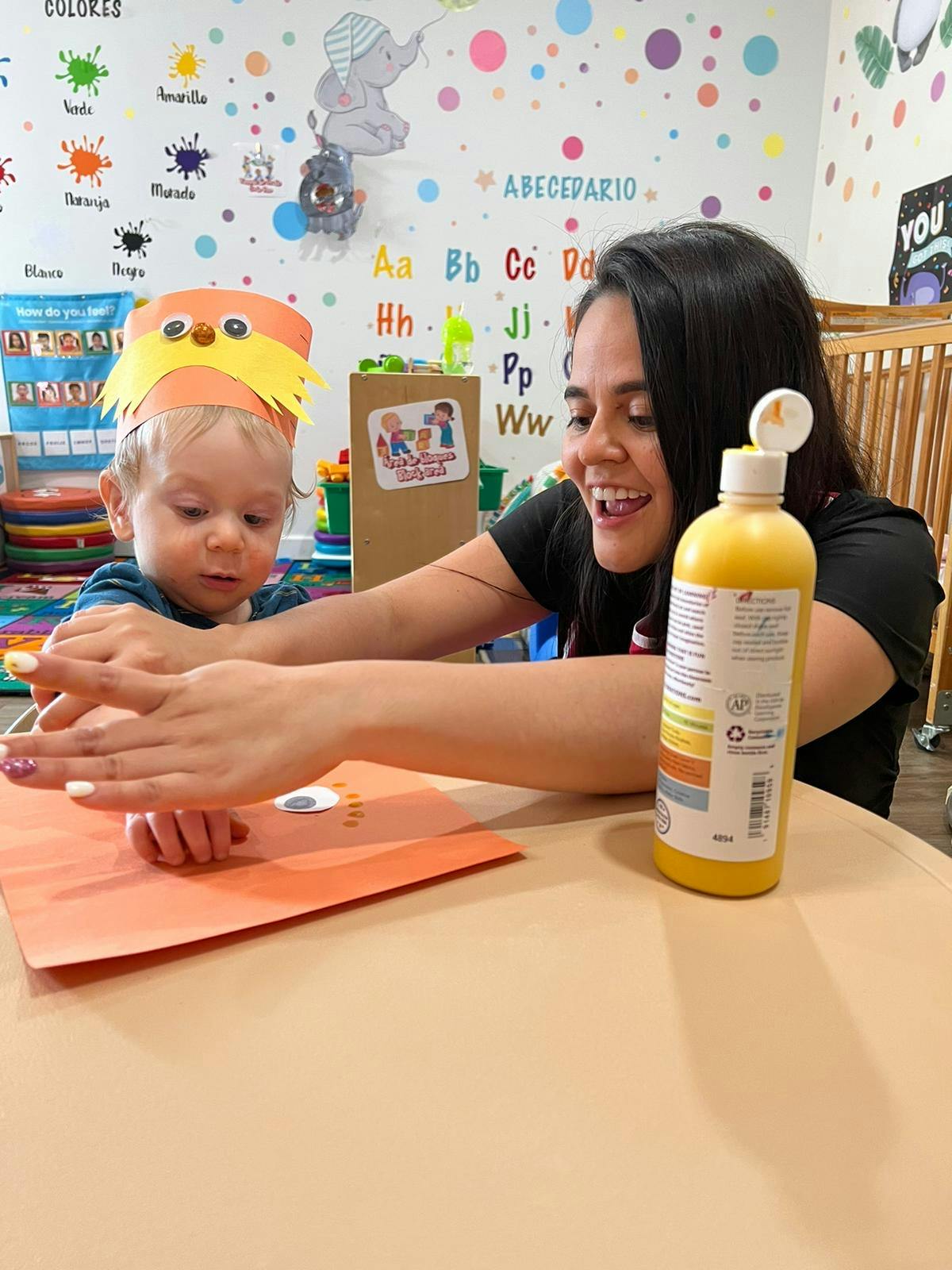 Adult and child with paper craft and bottle of paint