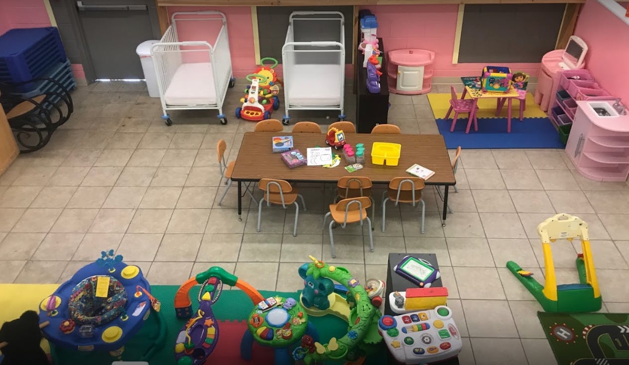 Playroom with a table and chairs, crib, and various toys