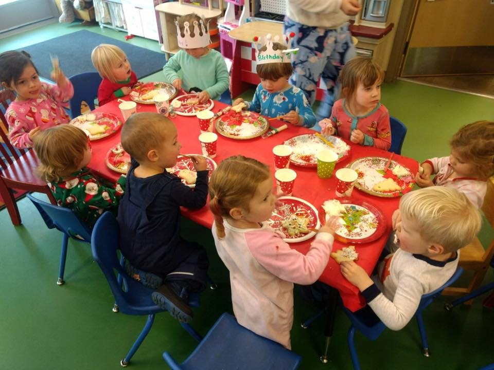 Children sitting around a table with plates of food