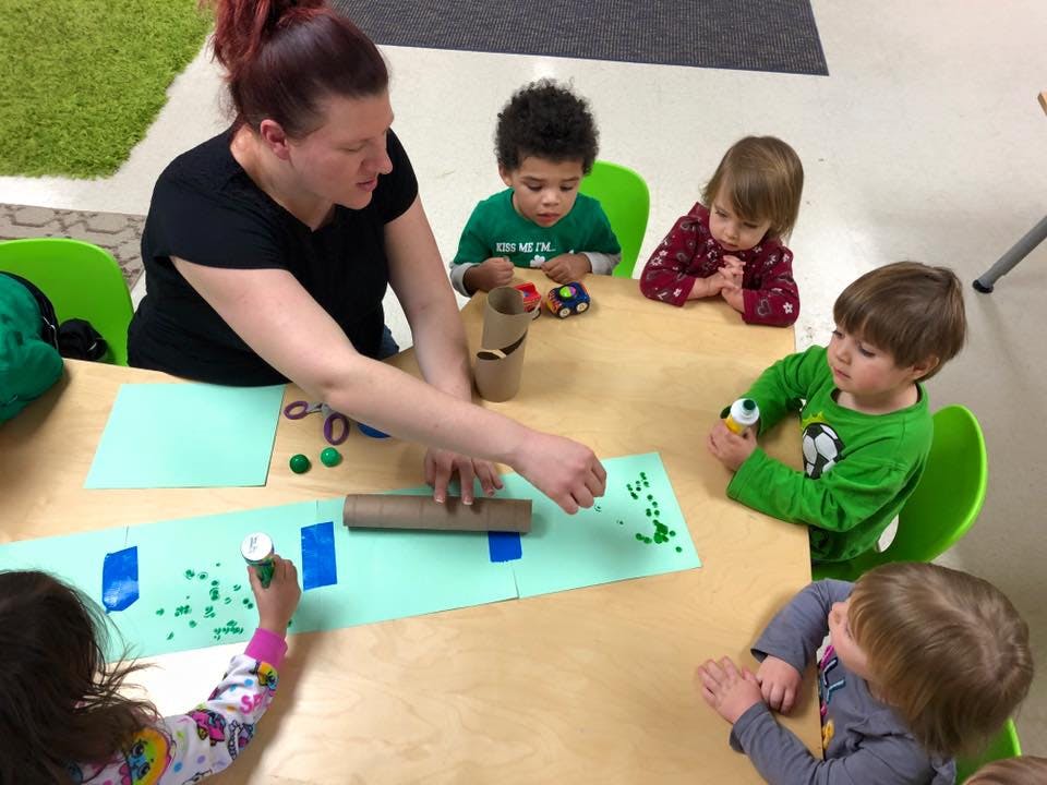Person and children doing an art activity at a table