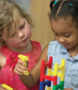 Two children playing with colorful building toys