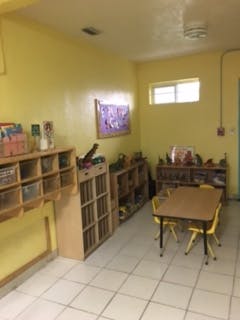 Classroom with tables, chairs, and shelves
