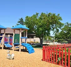 Playground with blue slides and red fence