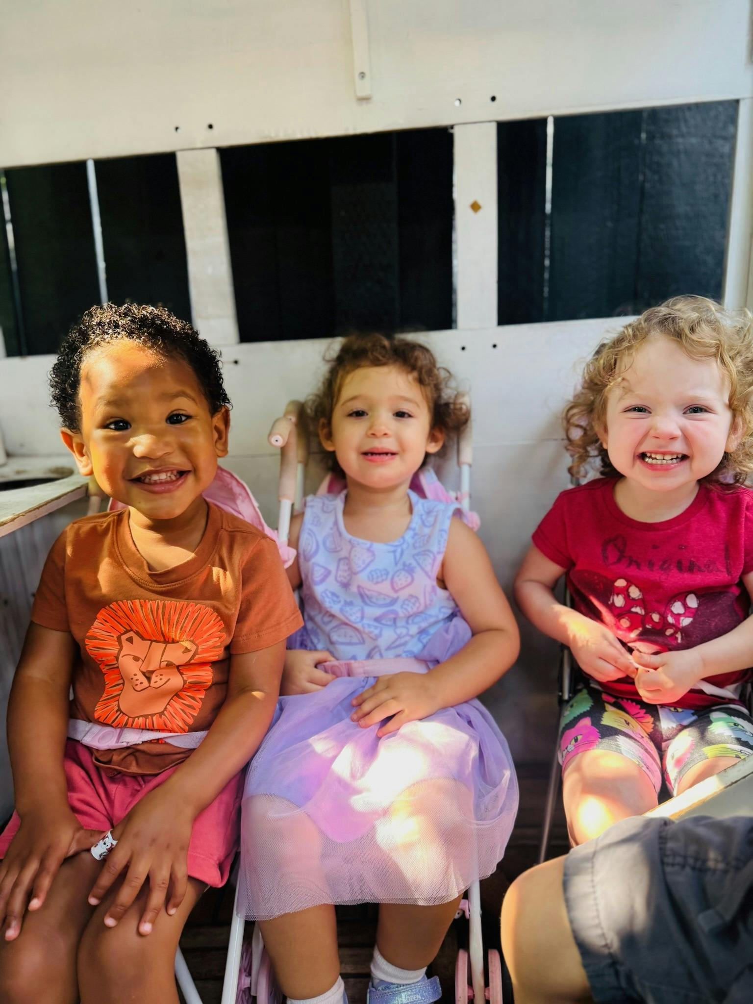 Three young children sitting in chairs