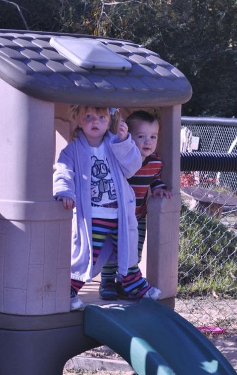Two children standing in a playhouse