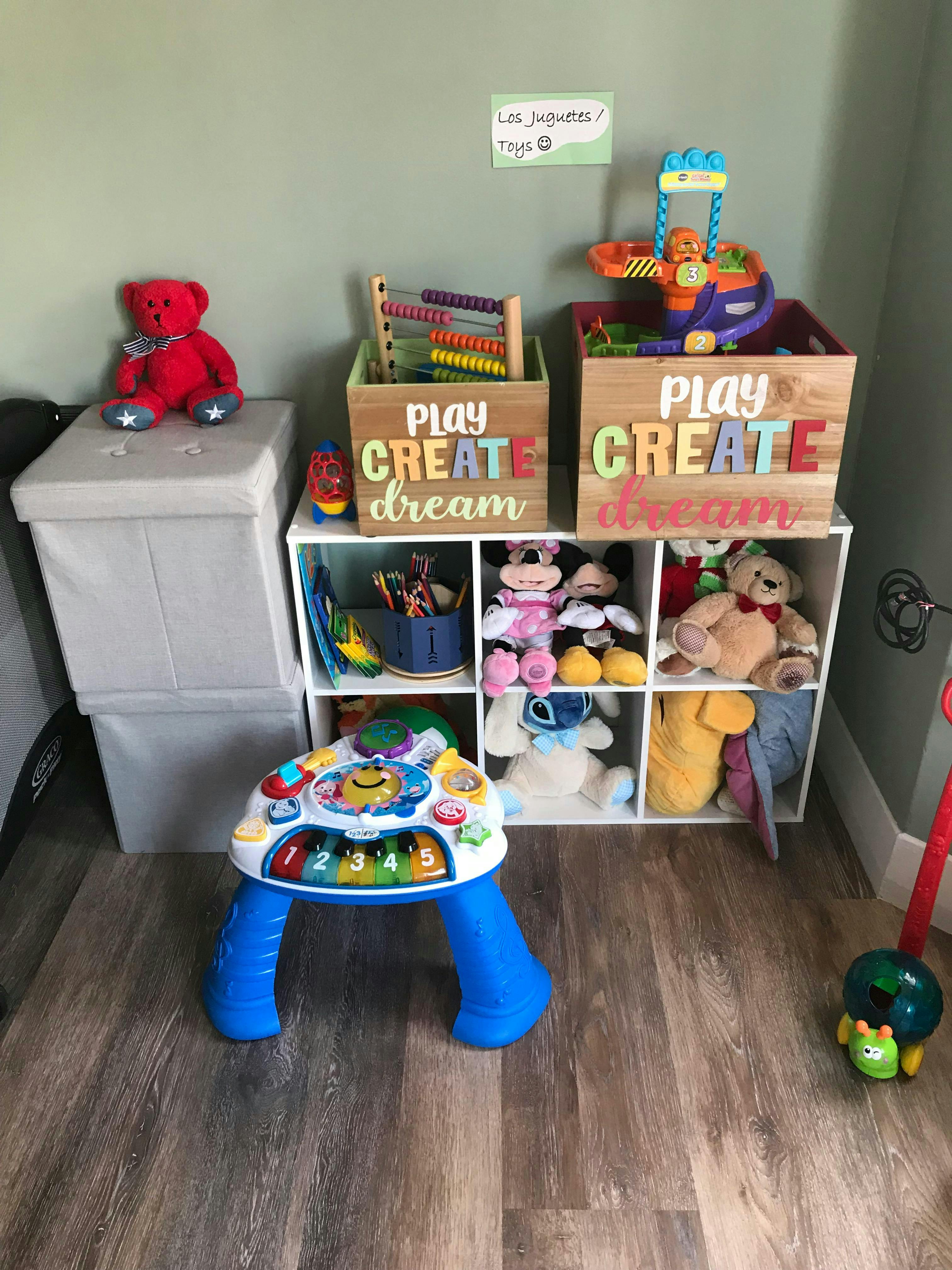 Child toys organized in bins and on a white shelving unit