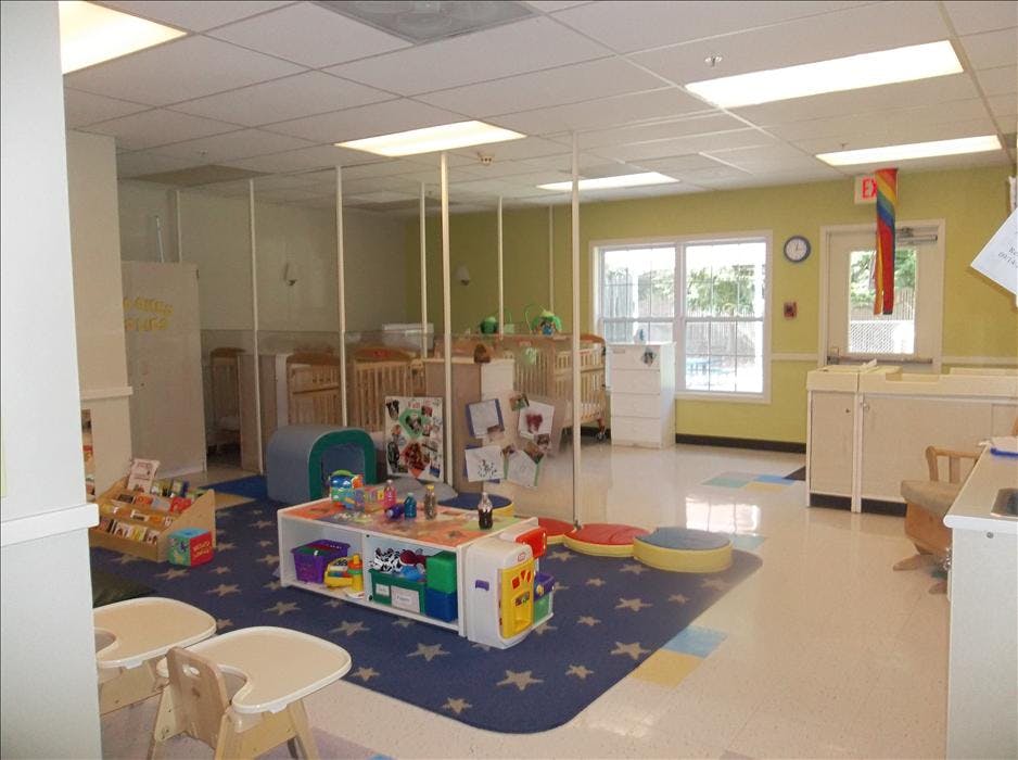 Cribs and play area in a brightly lit daycare classroom