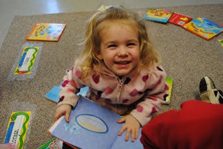 Child sitting on floor with open book