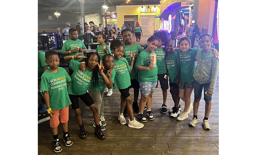 Group of children wearing green shirts from \"New Good Community Summer Camp 2025\"