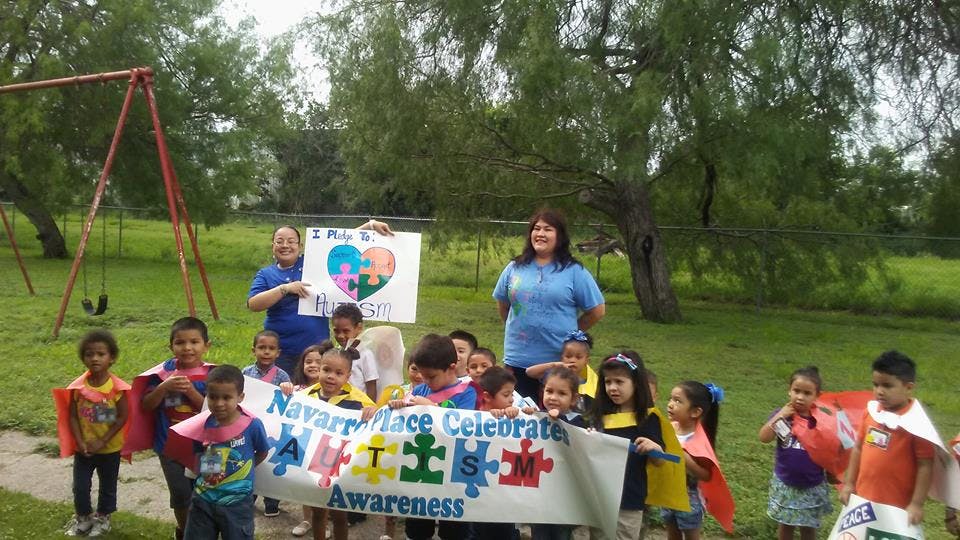 Adults and children holding a banner that reads "Celebrate Awareness"