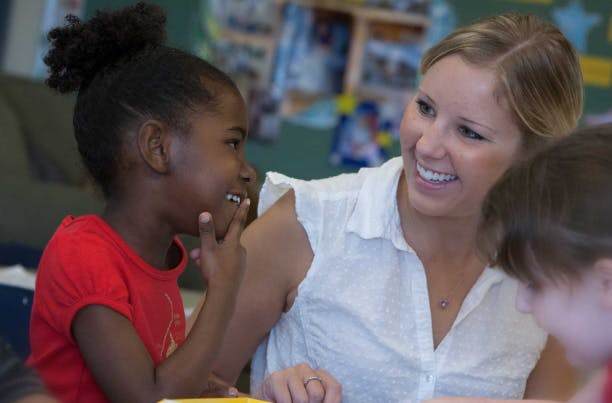 Adult and child interacting in a classroom