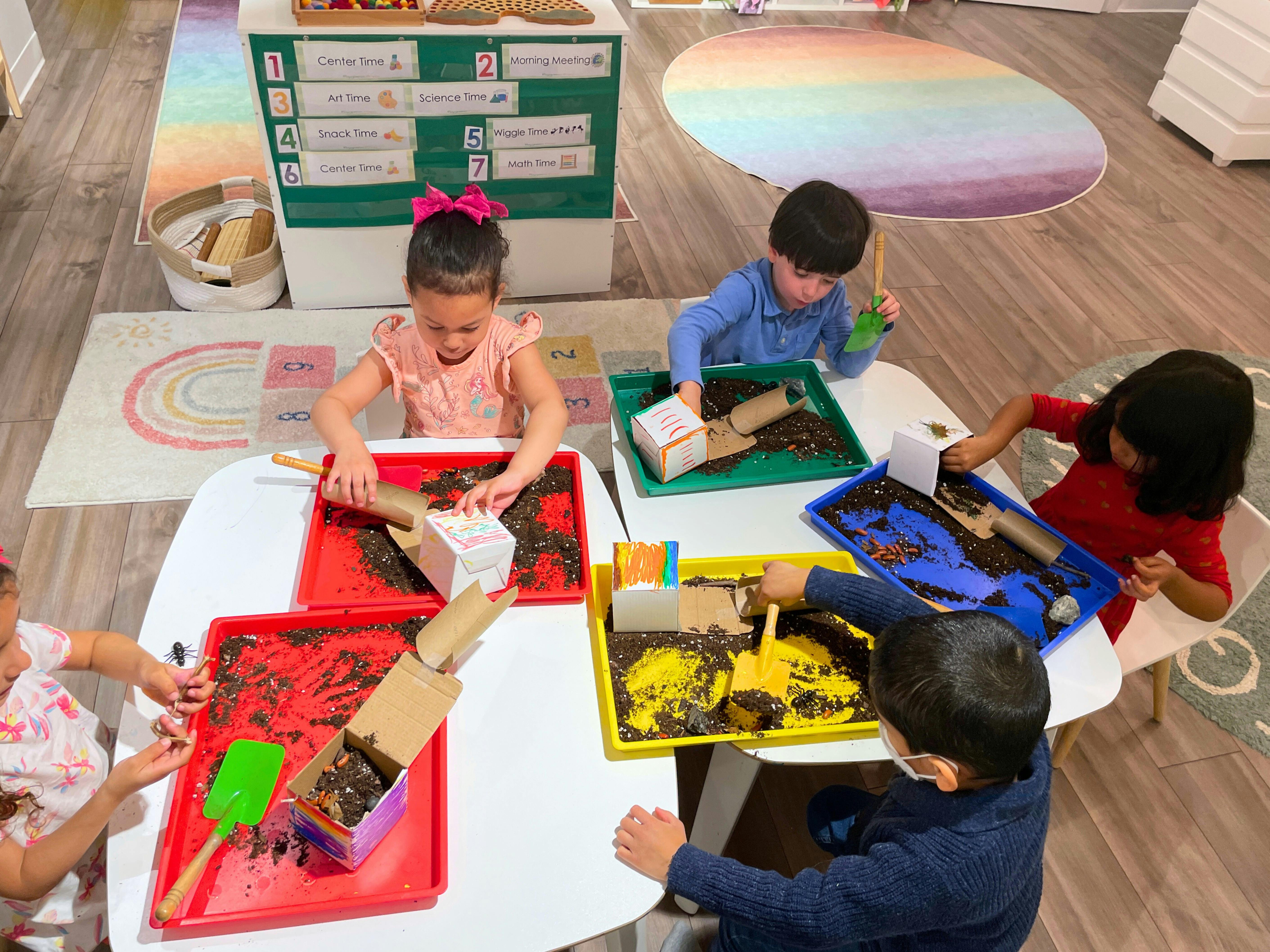 Children playing with sensory bins at a table