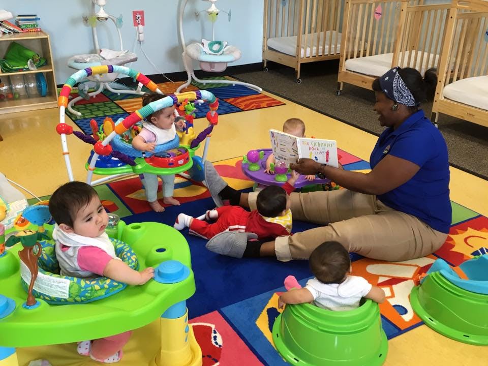 Person reading to multiple children in a play area