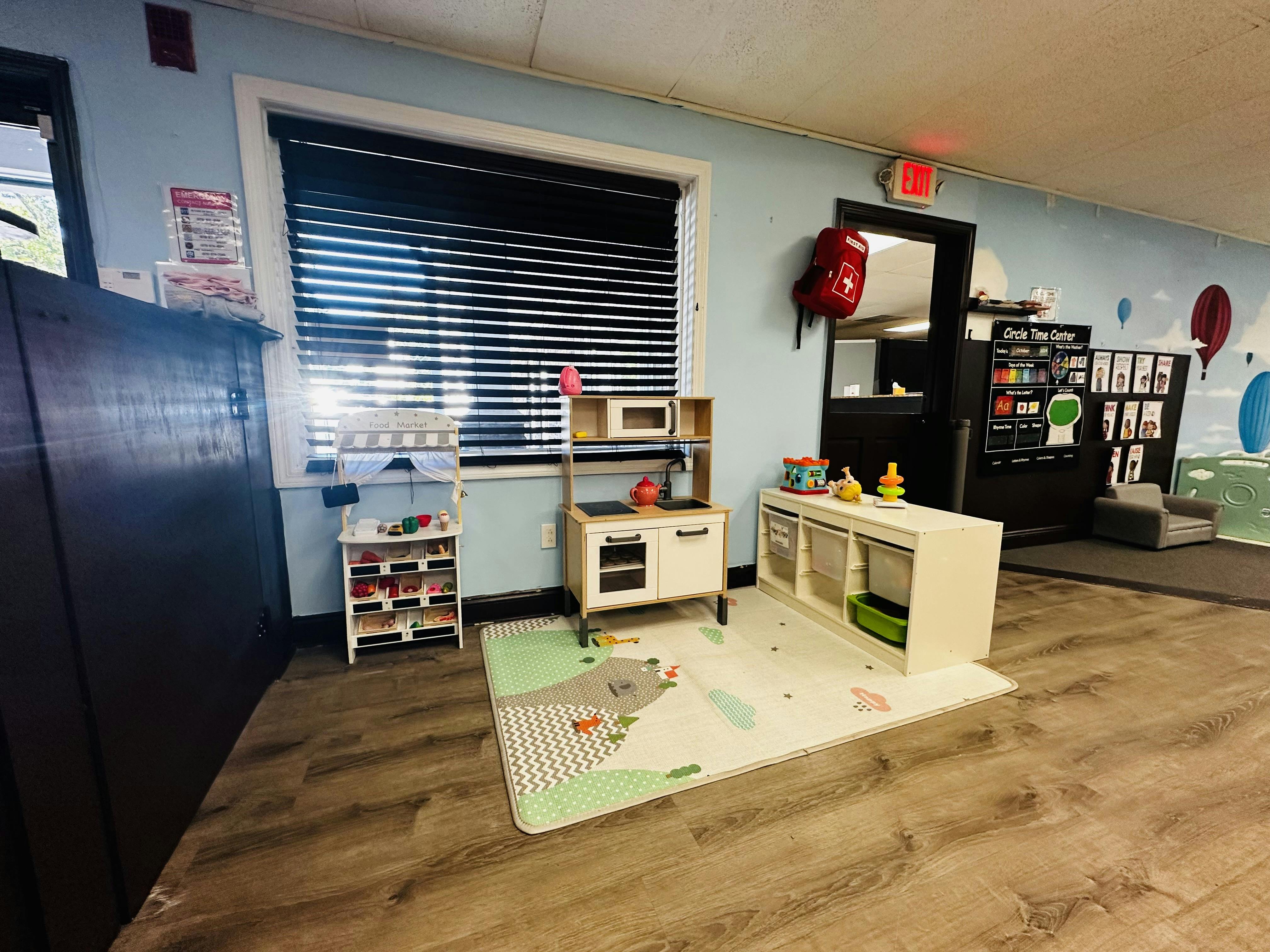 Playroom with toy kitchen, storage shelves, and play mat