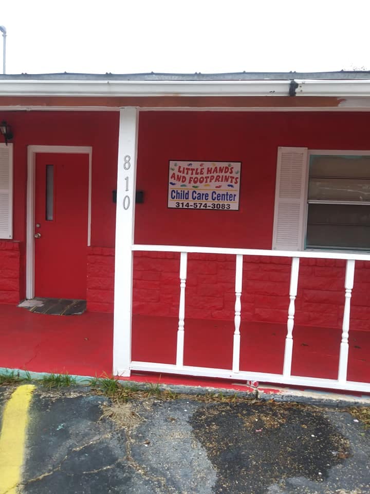 Red building with white porch railing and a sign for a child care center
