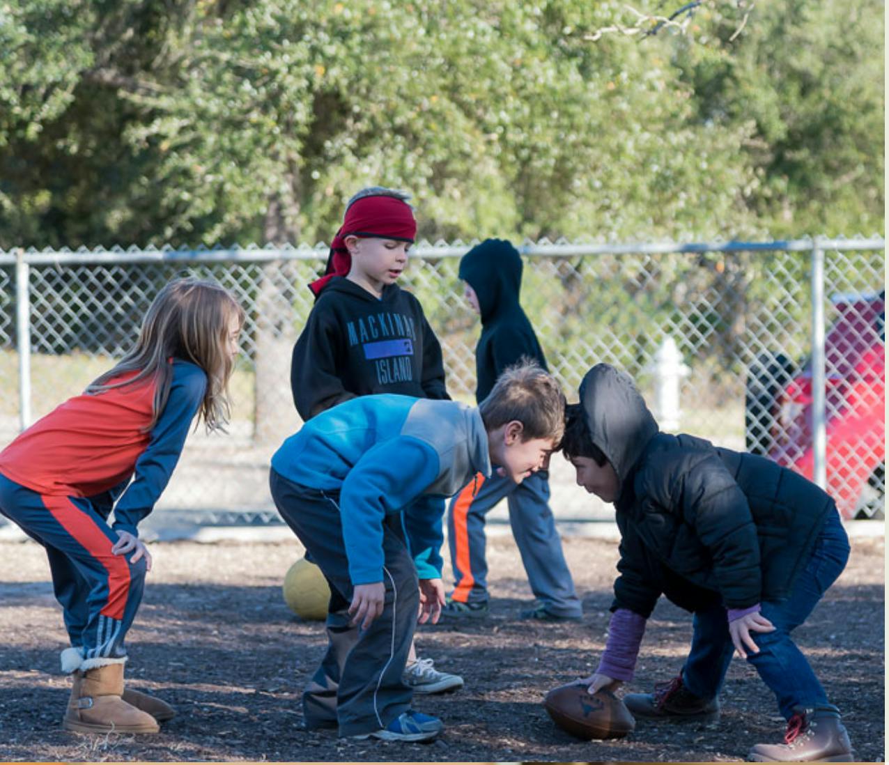 Children playing football outdoors