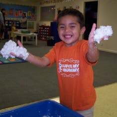 Child holding white fluffy material in both hands