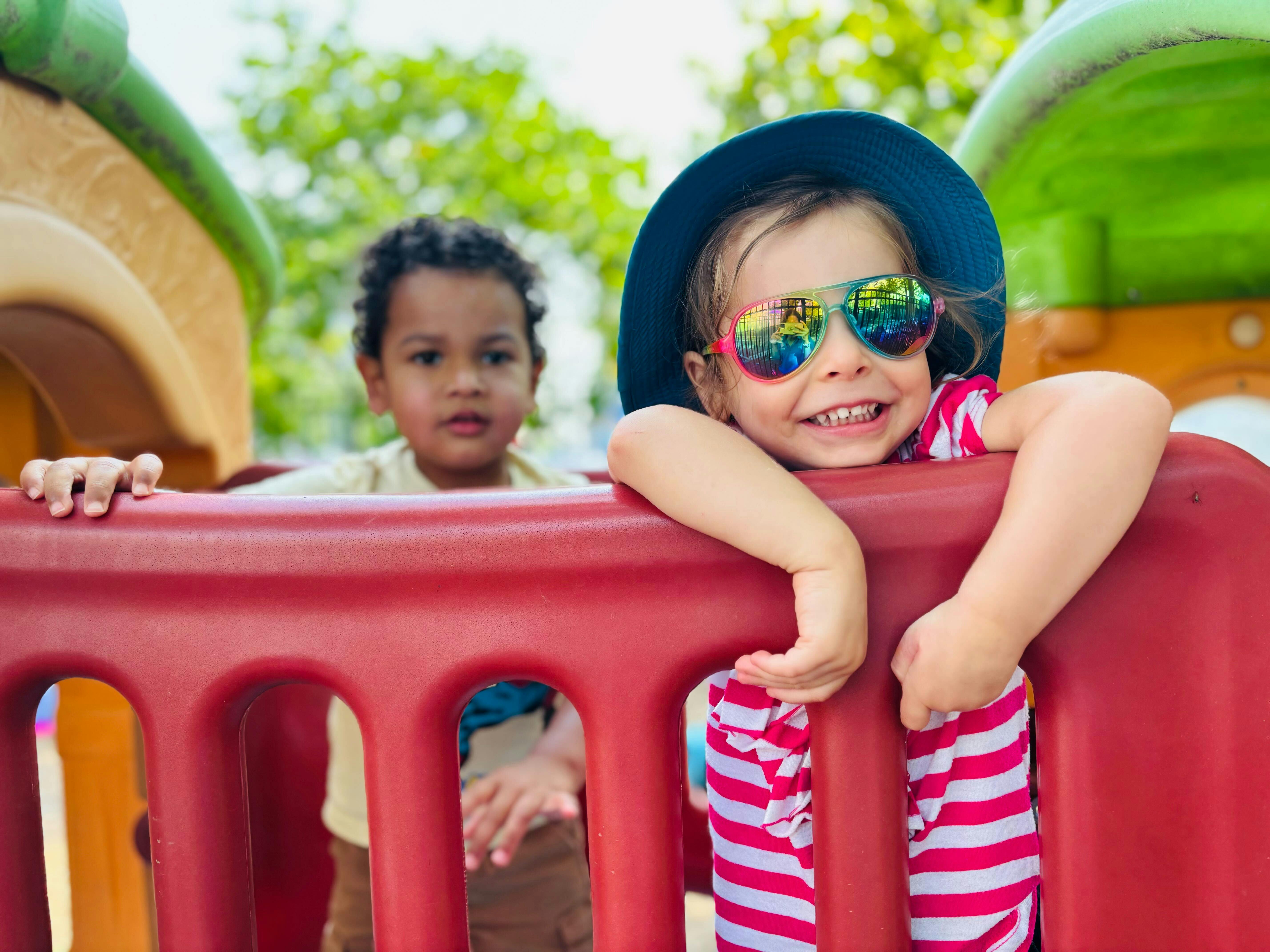 Two children playing on a jungle gym outdoors