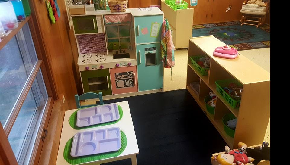 Play kitchen and small table with trays in a classroom