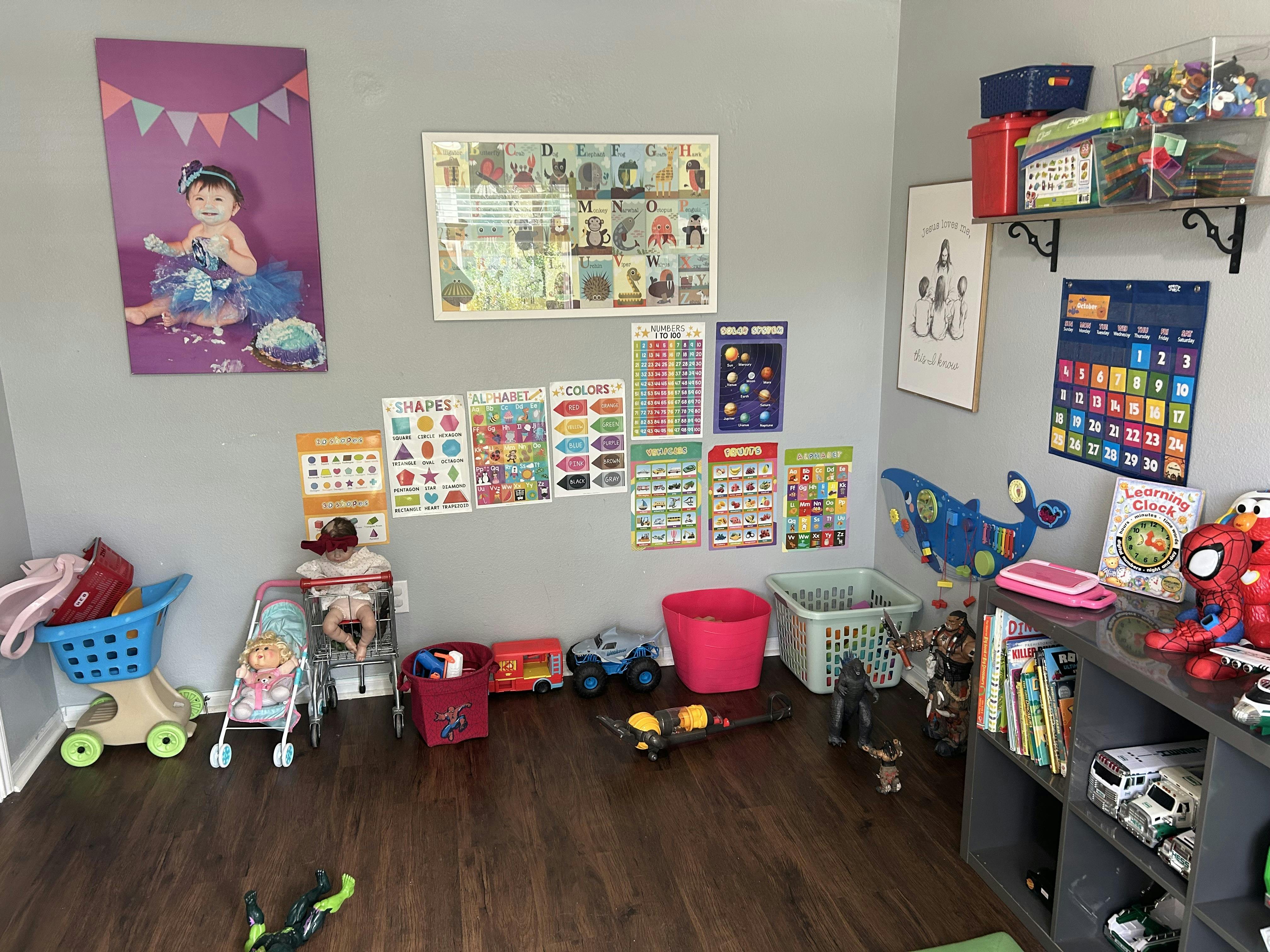 Child playroom with educational wall posters, toy storage, and various toy figures