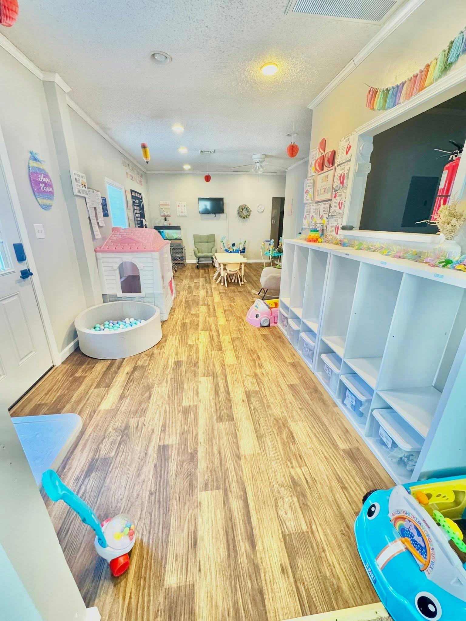Playroom with ball pit, small playhouse, and toy storage shelves