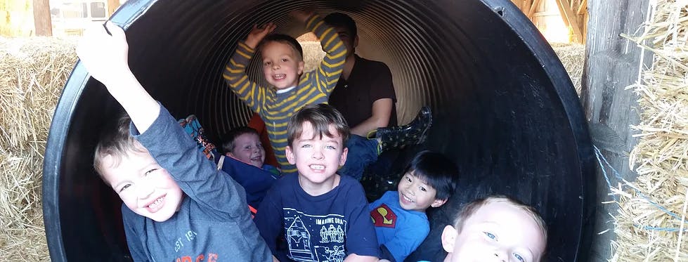 Multiple children and an adult inside a dark tunnel