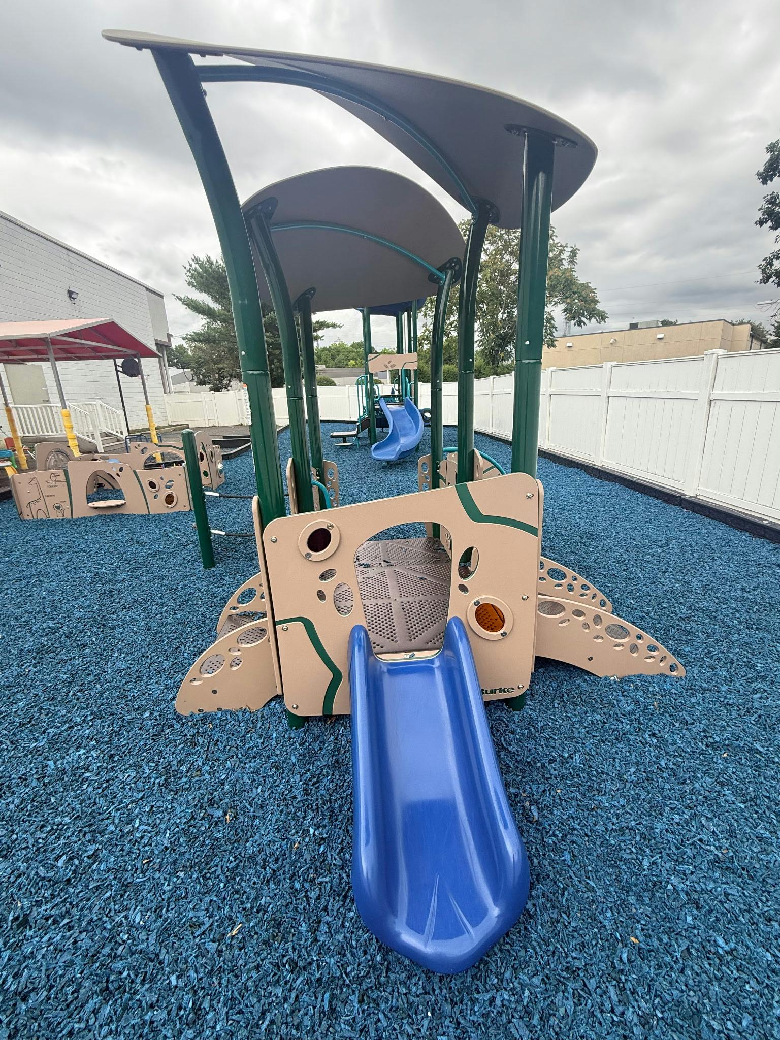 Playground equipment with slides and blue cushioned surfacing
