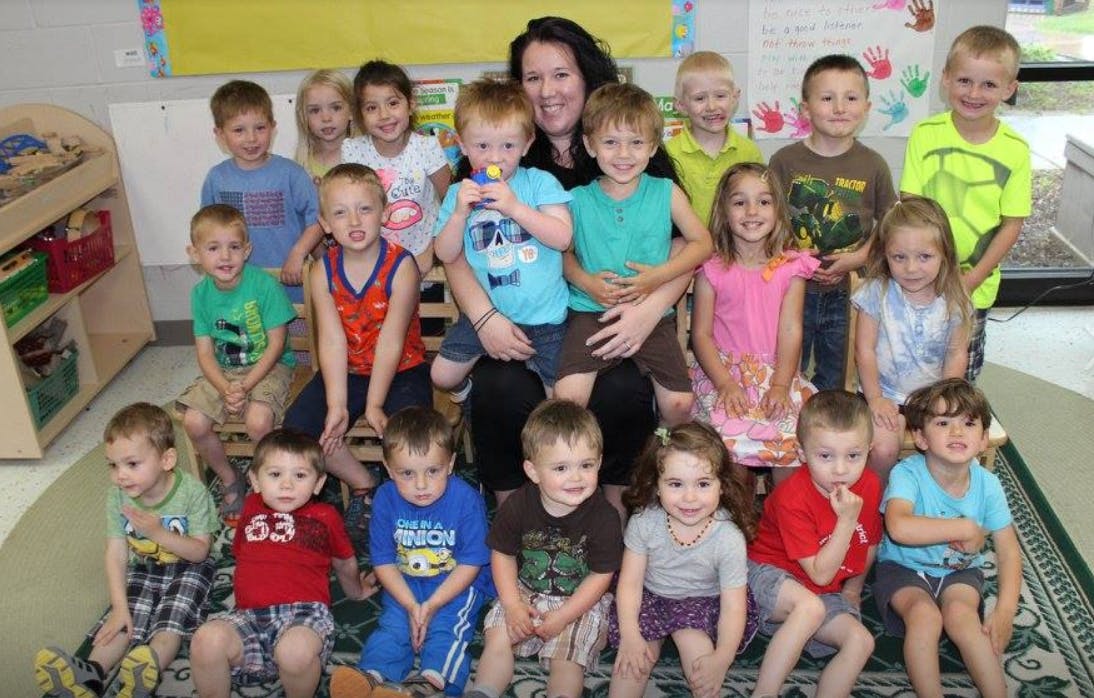 Adult and multiple children posing for a group photo