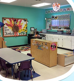 Classroom with tables, chairs, and a bulletin board with a turkey