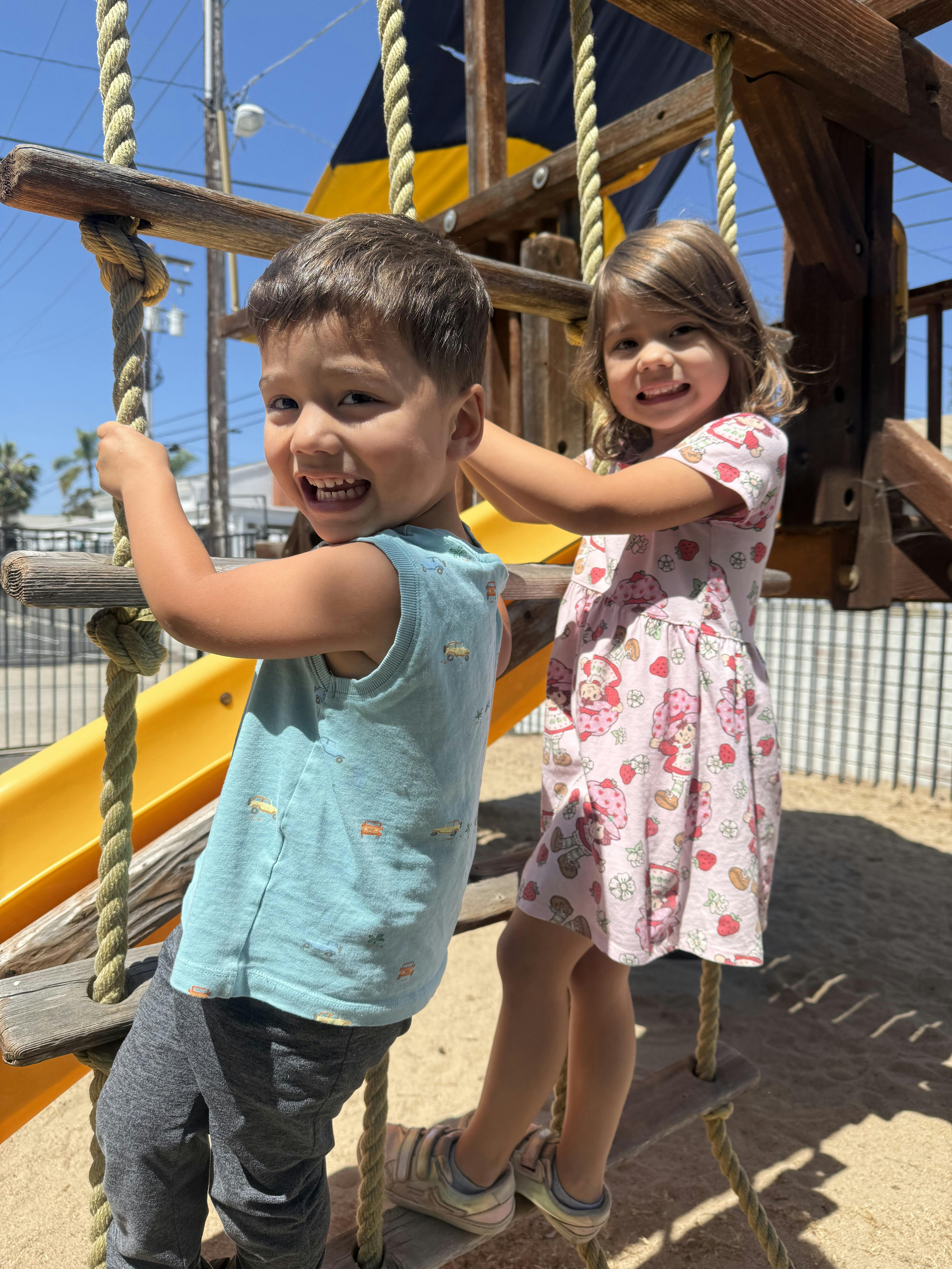 Two children playing on a playground ladder