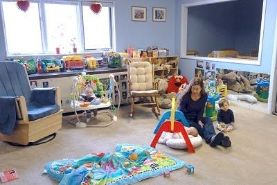 Adult and child sitting on floor in a room with toys